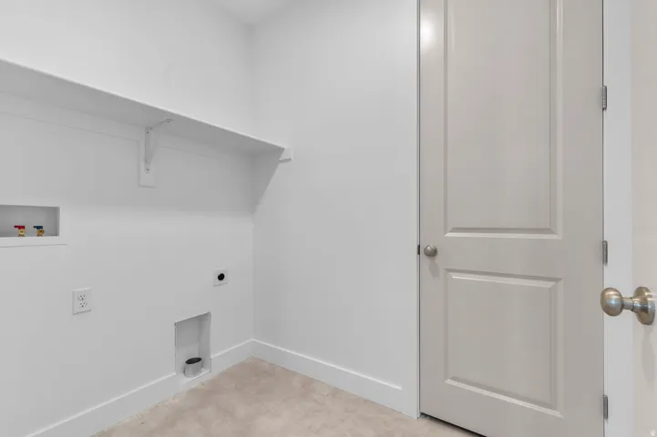 Laundry area featuring a built-in shelf, appliance hookups, light-colored carpeting, and a paneled door