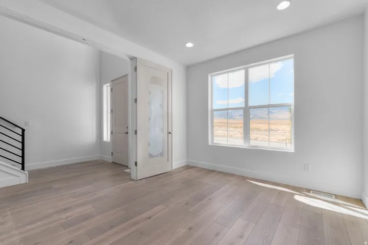 Wood-finish flooring, recessed lighting, and a transom window