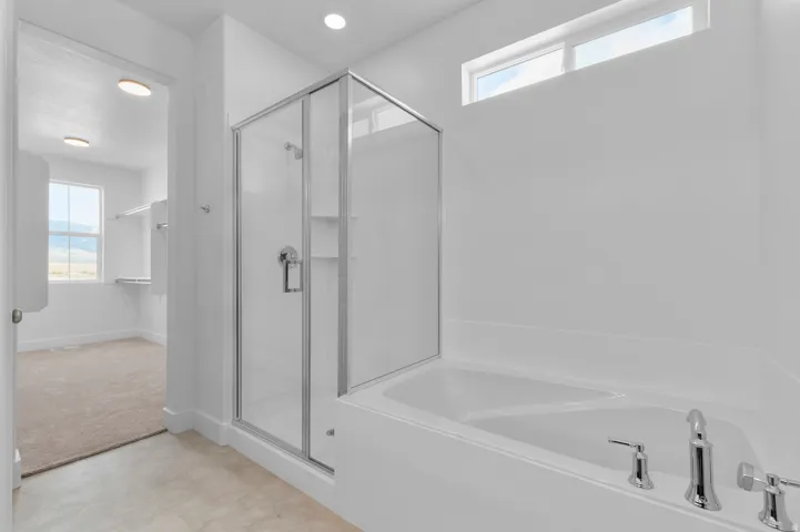 Walk-in shower with clear glass enclosure and chrome fixtures