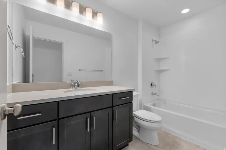 Dark wood-finish vanity with an integrated sink, light-toned countertop, and chrome fixtures