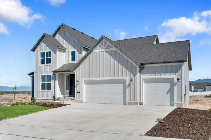 Modern farmhouse exterior with vertical siding, dark shingle roof, two-car garage, and concrete driveway