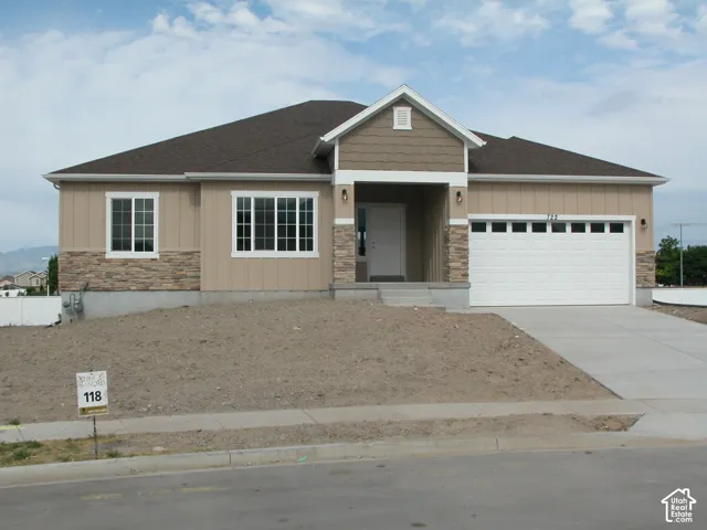 Front exterior with a covered entry, attached two-car garage, stone veneer accents, and a concrete driveway