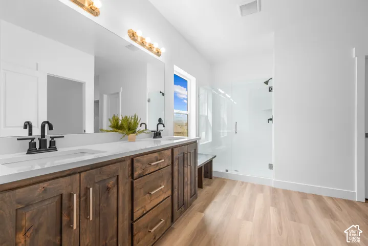 Dual vanity with dark wood-finish cabinetry, white countertop, and matte black fixtures