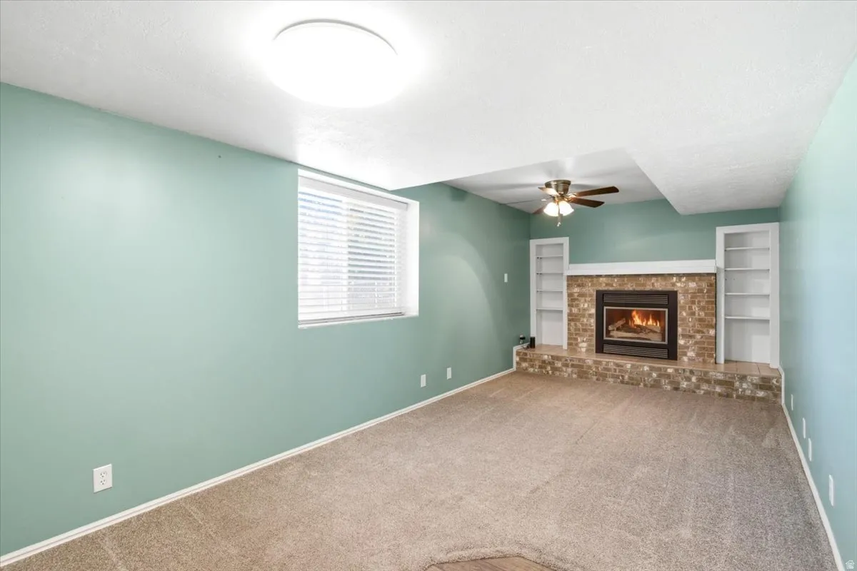 Built-in fireplace with a brick surround and hearth, flanked by two built-in shelving units