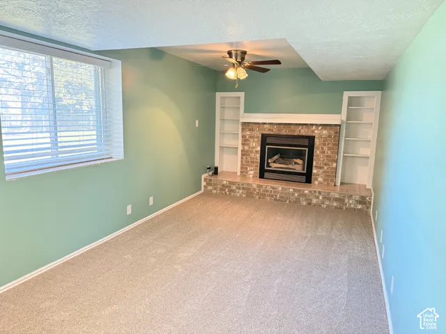 Brick fireplace with a raised hearth and white mantel, flanked by built-in bookshelves
