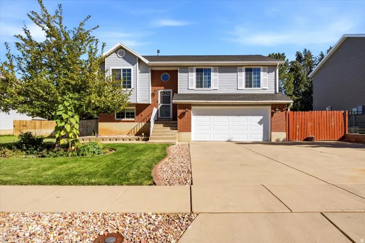 Two-story residence featuring brick and siding facade, an attached two-car garage, and a concrete driveway