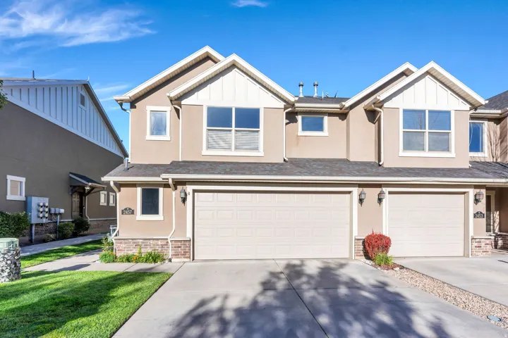 Stucco exterior with gabled accents, multiple windows, and an attached two-car garage