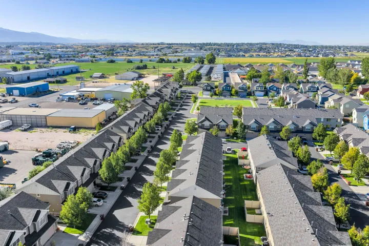 Residential community featuring multiple townhome-style residences with pitched roofs and individual exterior parking spaces