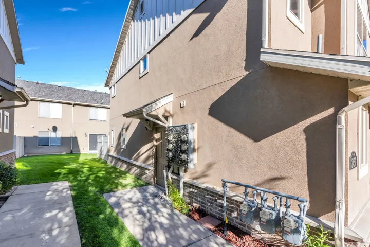 Stucco exterior with a peaked roofline, white eaves, and a covered entry