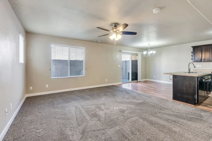 Recessed lighting, ceiling fan, wood-finish flooring, sliding glass door, and integrated breakfast bar