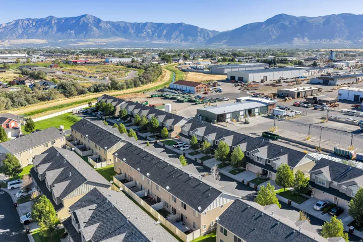Rows of properties with gray shingle roofs, beige siding, and small private yards