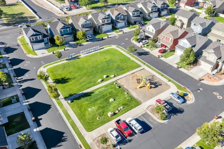 Community green space featuring a playground, sidewalks, and surrounding residential properties