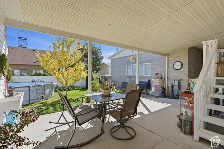 Covered concrete patio with recessed lighting, offering direct access to a grass lawn