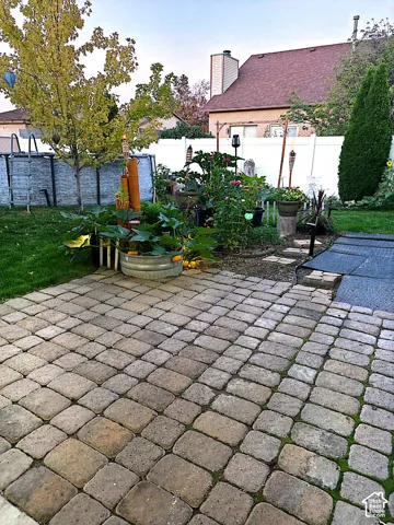 Paved patio area, raised garden bed, and privacy fencing