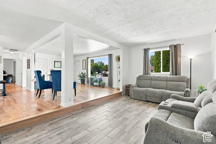 Open living area featuring wood-finish flooring, light-toned tile flooring, and multiple windows