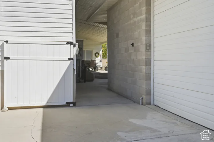 Concrete patio with a white vinyl fence and a white garage door