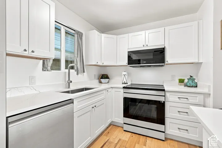 Modern kitchen featuring white shaker cabinetry, quartz countertops, a stainless steel dishwasher, a stainless steel range, and a built-in microwave