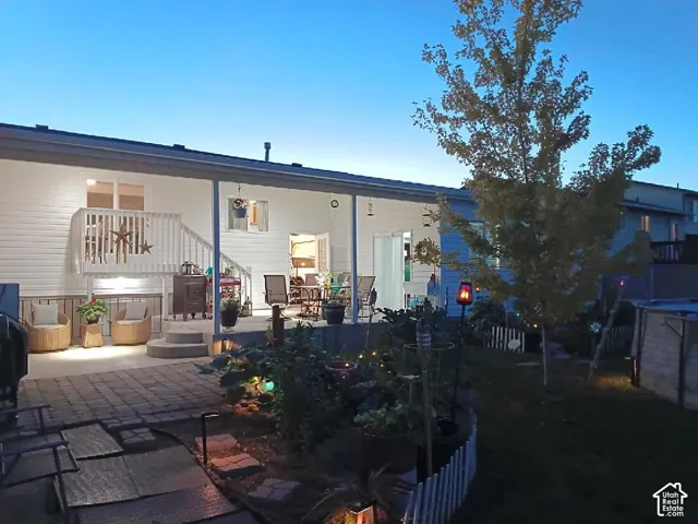 Rear exterior with white siding, covered patio, and multi-level deck with white railings