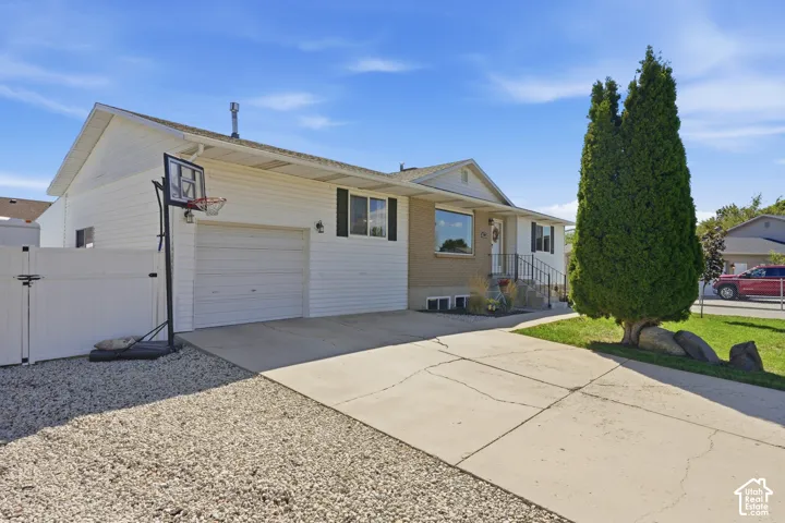 Single-story residence featuring white siding, a two-car garage, and a concrete driveway