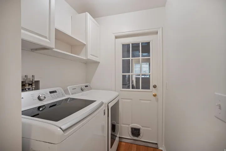 White shaker-style cabinetry with open shelving and wood-finish flooring