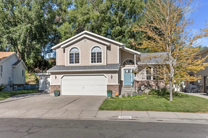 Stucco exterior with arched windows, an attached two-car garage, and a light blue entry door