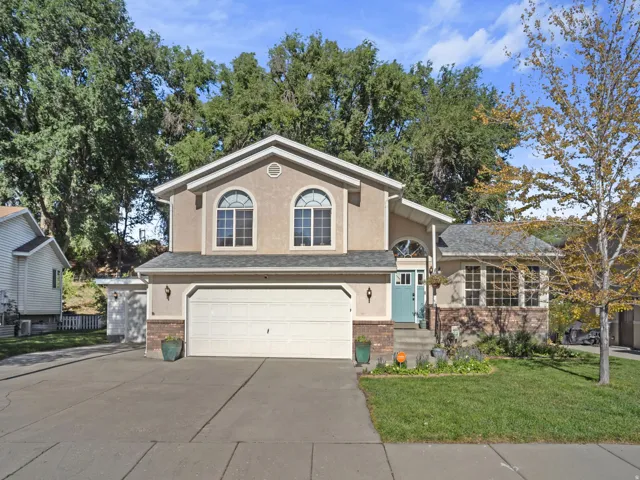 Two-story stucco exterior with arched windows, an attached two-car garage, and a concrete driveway