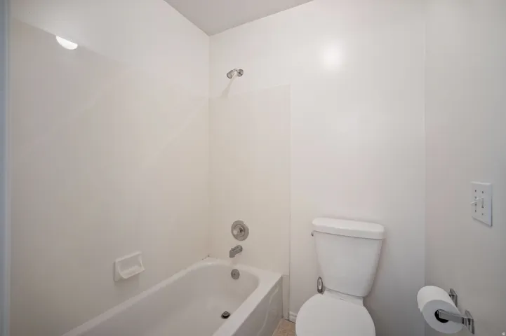 White bath and shower combination with chrome fixtures