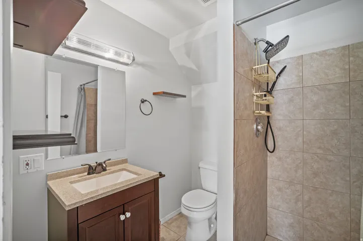 Vanity with integrated sink, stone-finish countertop, and dark wood cabinetry