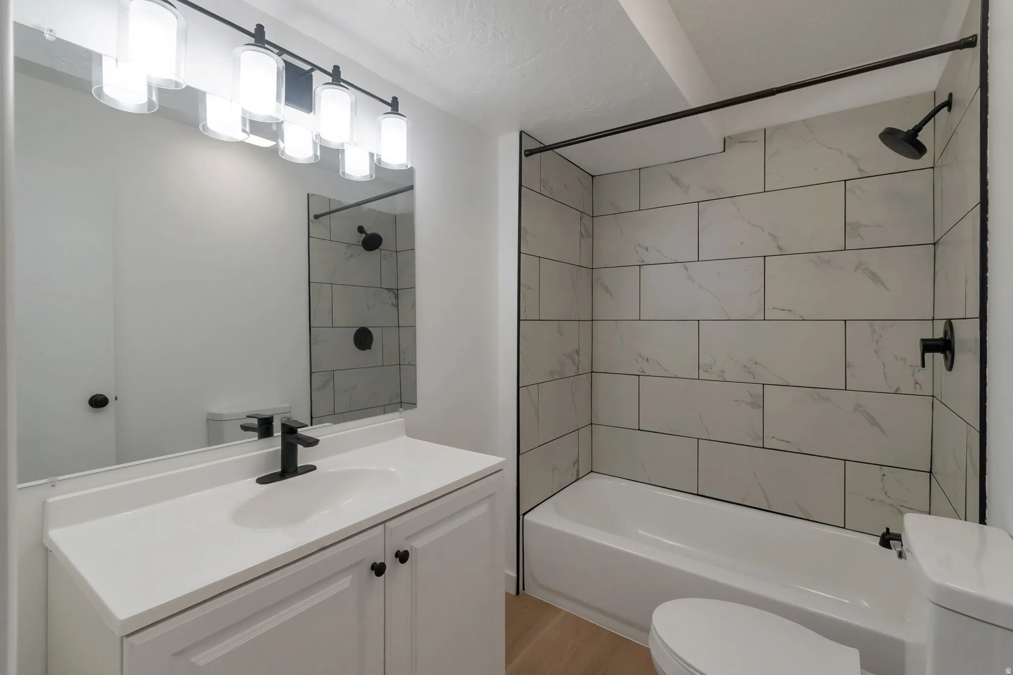 White vanity with a single basin sink, matte black faucet, and cabinet storage