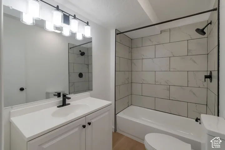 White vanity with a single basin sink, matte black faucet, and cabinet storage