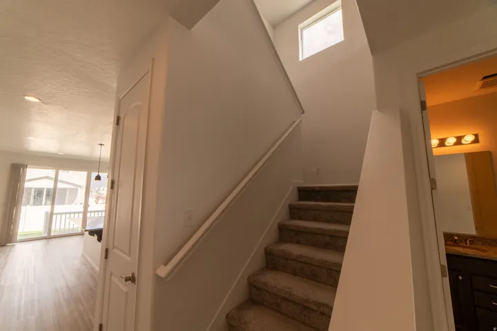 Carpeted staircase with a transom window above