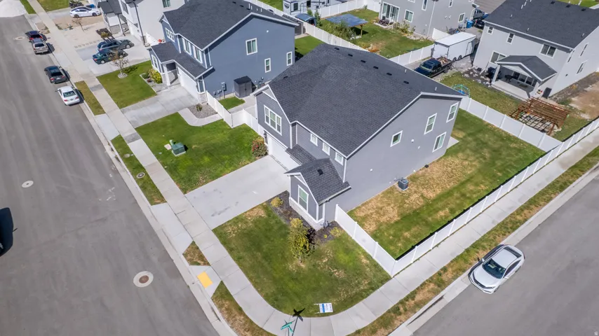 Gray residence featuring a dark roof and white fencing