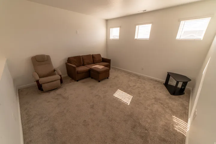 Carpeted room with white walls and multiple windows