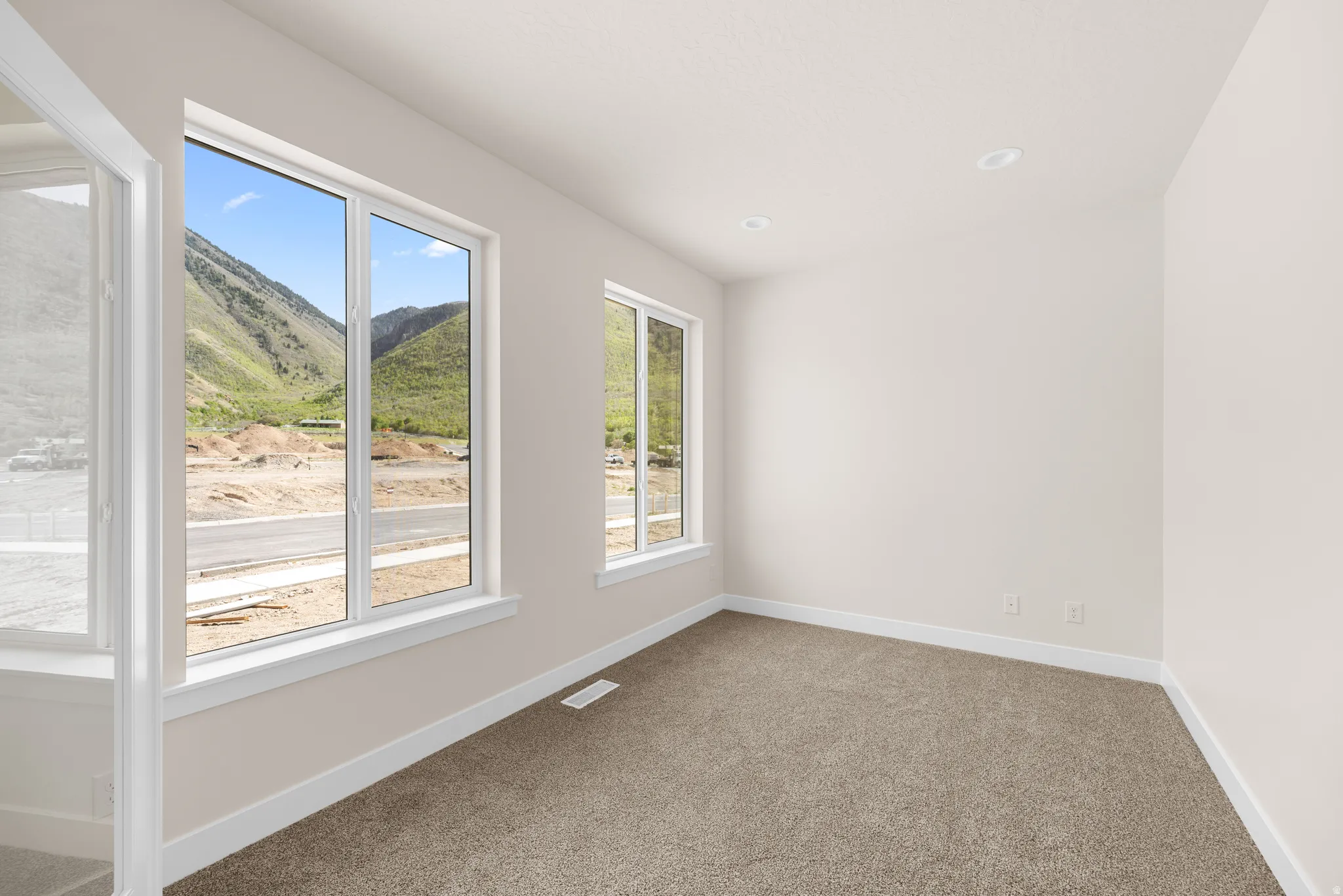 Bright interior space featuring light-toned walls, recessed lighting, and carpet flooring