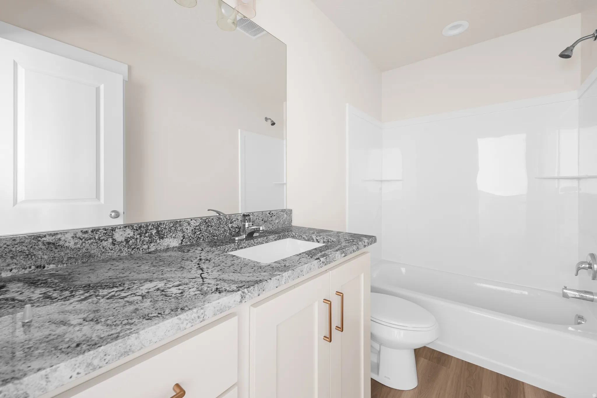 Vanity with a light-toned countertop, integrated sink, and chrome faucet