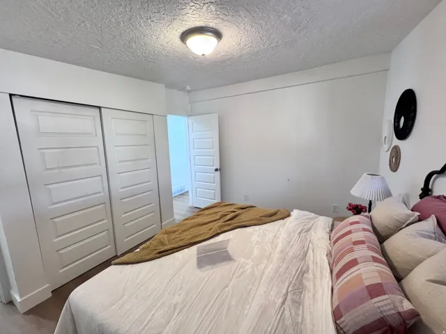 Sliding panel doors, wood-finish flooring, and a flush mount ceiling light