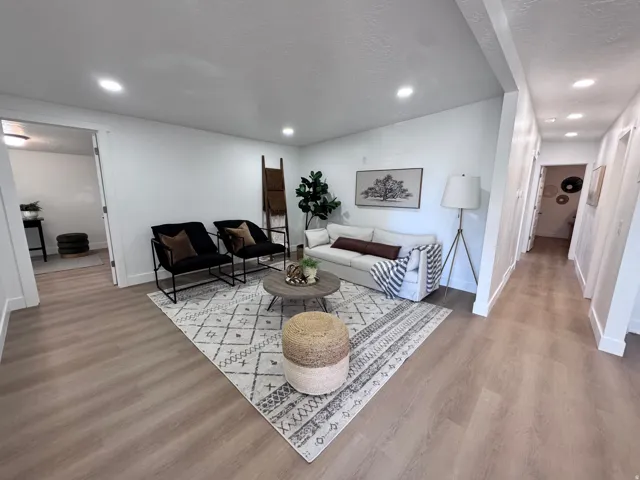Recessed ceiling lighting, light wood-finish flooring, and white painted walls
