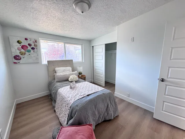 Wood-finish flooring, white walls, and a window with natural light