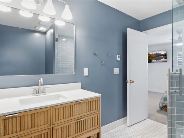 Vanity with wood-finish cabinetry, white countertop, and integrated sink