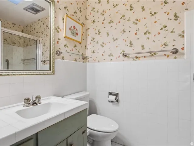 White tile wainscoting with decorative wallpaper accent