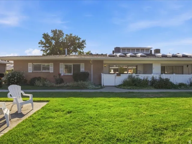 Brick exterior with white shutters and a white picket fence
