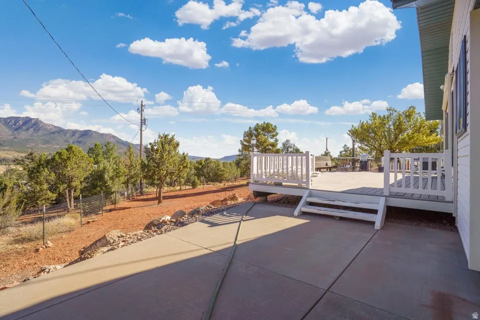 Expansive concrete patio with white railing deck and steps