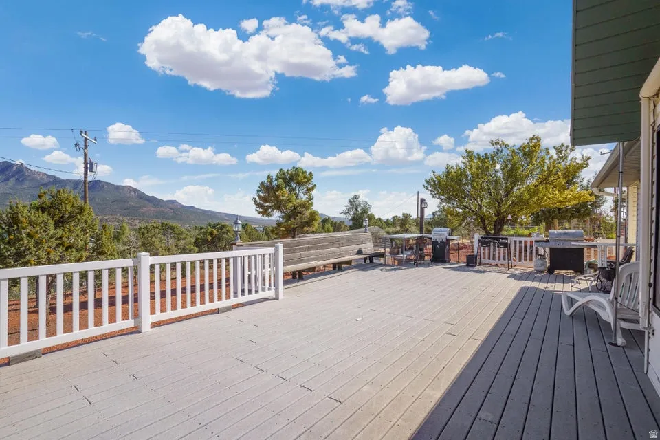 Expansive outdoor deck with mountain scenery, wood-finish decking, and white railing