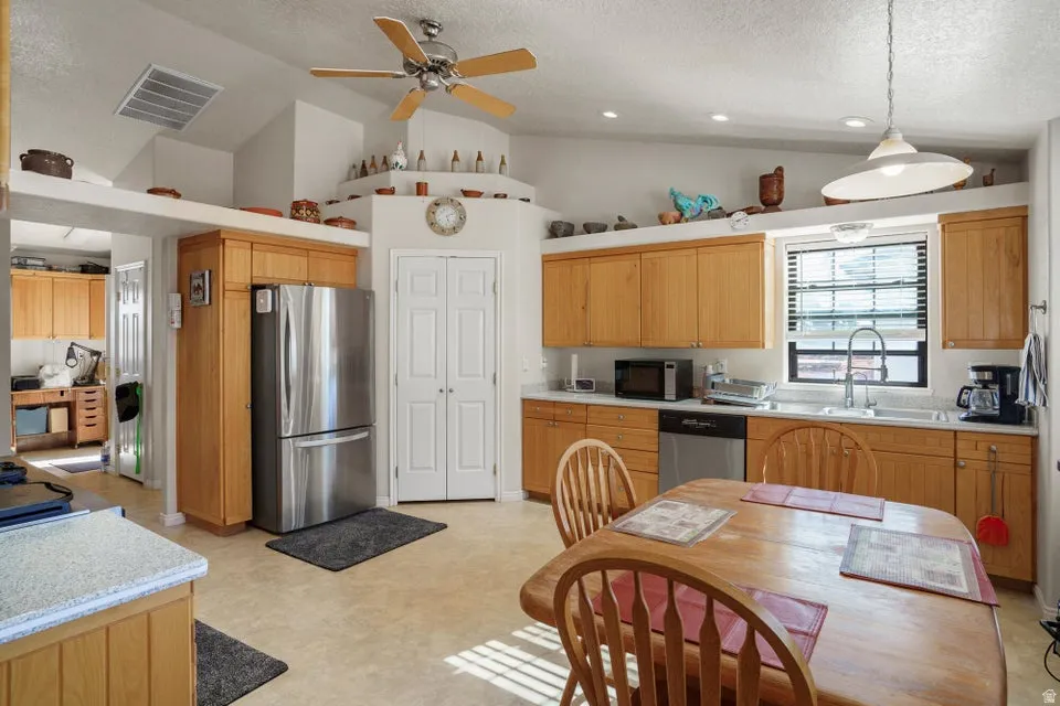 Kitchen featuring wood-finish cabinetry, stainless steel refrigerator, and recessed lighting