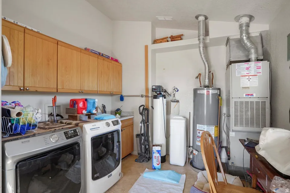 Wood-finish cabinetry, countertop with integrated sink, water heater, water filtration system, and forced-air unit