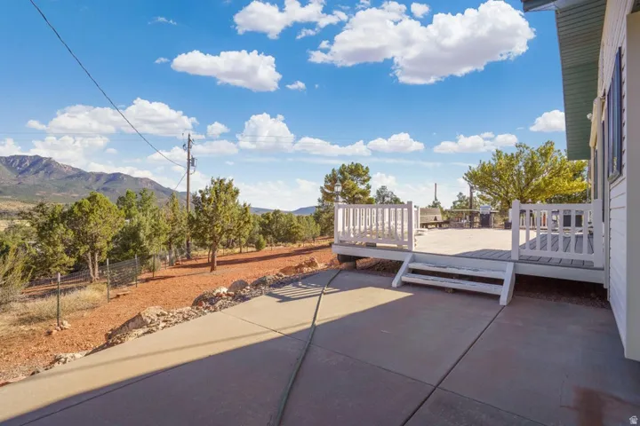Expansive concrete patio with white railing deck and steps