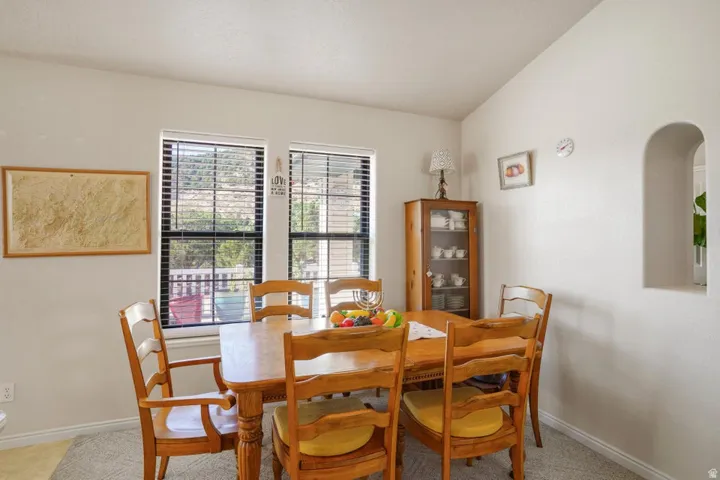 Dining area featuring two windows with horizontal blinds, a wall niche, and light-toned walls