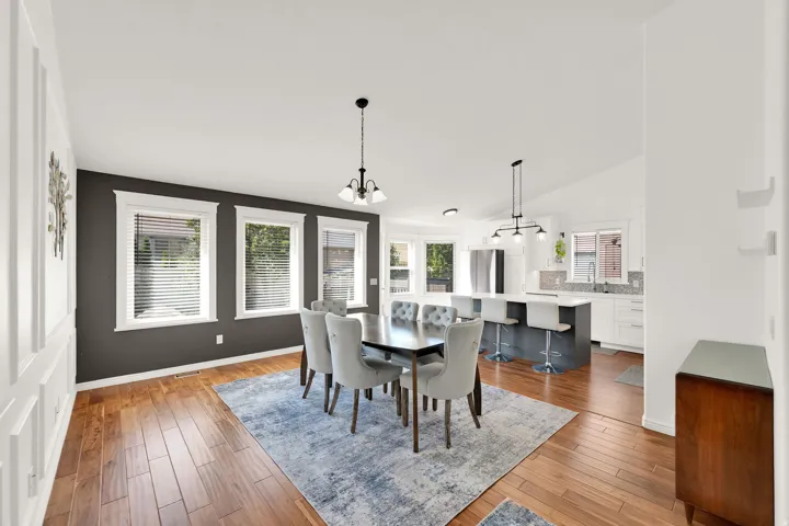 Hardwood flooring throughout, white wainscoting, vaulted ceilings, kitchen with a central island and white cabinetry