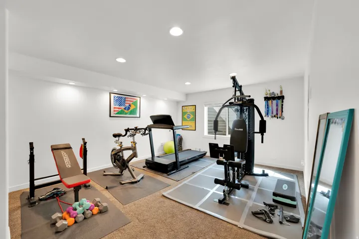 Recessed lighting, white painted walls, and neutral carpet flooring