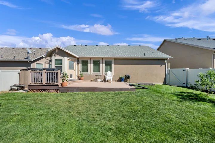 Expansive backyard with a two-tiered deck, privacy fencing, and multiple windows